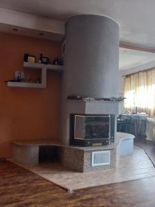 uma lareira numa sala de estar com um fogão em Къща село Катунци em Sandanski