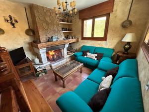 a living room with a blue couch and a fireplace at Paleolítico rural 