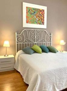 ein Schlafzimmer mit einem Bett mit zwei Lampen und einem Gemälde in der Unterkunft Stella del Cilento B&B Vista Golfo in Agropoli