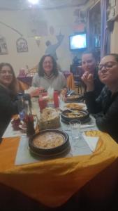 een groep mensen die rond een tafel eten bij Gîte Ait Bouguemez in Azilal