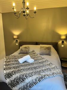 a bed with a black and white blanket and pillows at La Glycine in Chamoux-sur-Gelon
