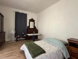 een slaapkamer met een bed, een tafel en een spiegel bij Studio Cosy - Cœur Perpignan in Perpignan