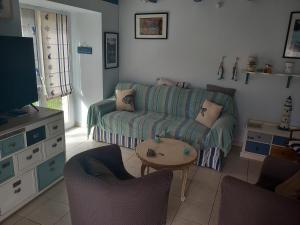 ein Wohnzimmer mit einem Sofa und einem Tisch in der Unterkunft Charmante maison au calme in Marzan