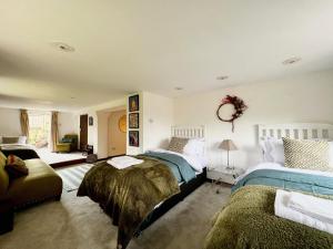 芬赫斯特的住宿－Hilltop walkers paradise with a view, sleeps 10，一间带两张床和一张沙发的卧室