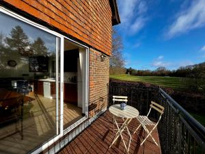 a patio with a table and chairs on a balcony at Hilltop walkers paradise with a view, sleeps 10 in Fernhurst