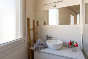 La salle de bains est pourvue d'un lavabo blanc et d'un miroir. dans l'établissement Grand appartement moderne très proche de Paris centre, à Malakoff