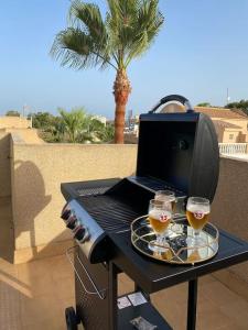 a table with two glasses of wine and a laptop at Sol Beach, Cabo Roig in Orihuela Costa