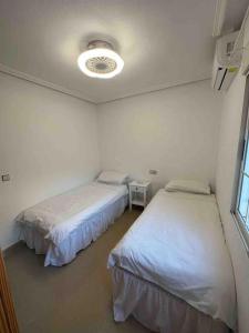 a room with two beds and a ceiling at Sol Beach, Cabo Roig in Orihuela Costa +22 photos