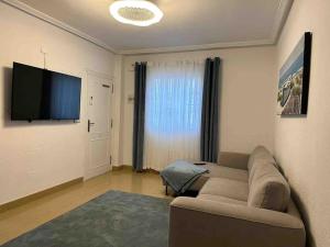 a living room with a couch and a flat screen tv at Sol Beach, Cabo Roig in Orihuela Costa