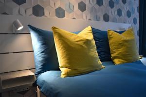 a blue bed with two yellow pillows on it at Chambre d'hôte Valère in Sion