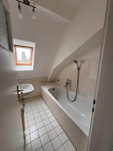 Baño blanco con bañera y lavamanos en Bohlen-Mühle - Monteurzimmer Reuhl en Mühltal