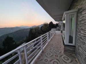 a balcony of a house with a view of the mountains at Abhi's Cottage in Mukteswar