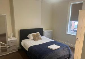 a bedroom with a bed with two towels on it at Rose House in Derby