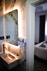 a bathroom with a sink and a mirror on a wall at Horizont Apart-Hotel in Shkodër
