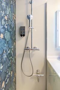 La salle de bains est pourvue d'une douche avec un tuyau. dans l'établissement Chambre d'Amis - Chambres d'Hôtes-B&B-Guest House, à Paris