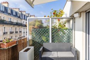 a balcony with a chair and a view of a city at Chambre d'Amis - Chambres d'Hôtes-B&B-Guest House in Paris