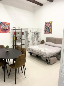 a bedroom with a bed and a table and chairs at Napolidays Rua Catalana Apartment in Naples +23 photos