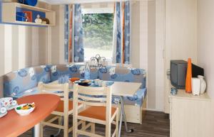 a kitchen with a table and a dining room at Camping La Châtaigneraie in Agos-Vidalos