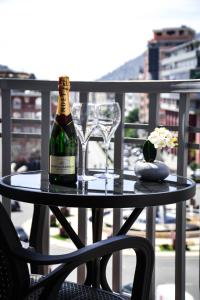 una botella de vino y copas en una mesa del balcón en Horizont Apart-Hotel, en Shkodër