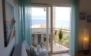 a room with a balcony with a view of the ocean at Apartments Klementina in Postira