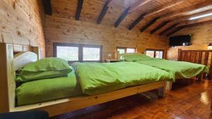 um quarto com uma cama grande e lençóis verdes em Zenith Campsite Apartments em Nikšić