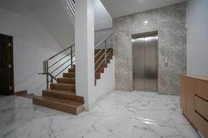 a lobby with a staircase with a door and a lobby at Residence 8 in Palembang