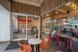 a restaurant with orange chairs and a table and tables and chairs at Residence 8 in Palembang