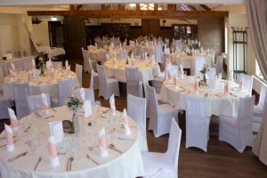 a room full of tables and chairs with white table cloth at Hotel Grohnder Fährhaus in Emmerthal