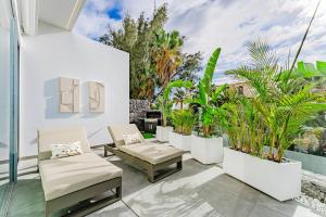 un patio al aire libre con sillas y plantas en Villa Larisa en Callao Salvaje