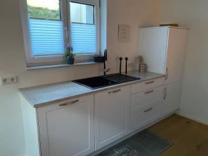 a kitchen with white cabinets and a white refrigerator at Schöne Wohnung nahe Nürnberg, 60 qm, 3 Pers. WLAN in Stein