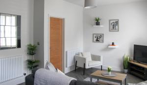 a living room with a couch and a tv at New, Luxury Apartment in Town Centre in Cheltenham