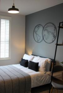 a bedroom with a bed with two clocks on the wall at New, Luxury Apartment in Town Centre in Cheltenham