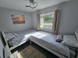 two beds in a room with a window at Lakeside Lodge 84 in Caeathro +20 photos