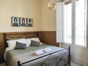 a bedroom with a bed with three pictures on the wall at Noù la tua casa in Puglia in Alberobello
