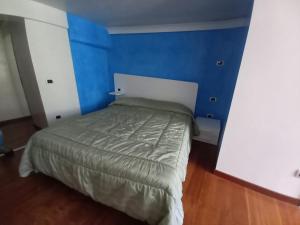 a bed in a room with a blue wall at HOME SWEET HOME in Rovereto