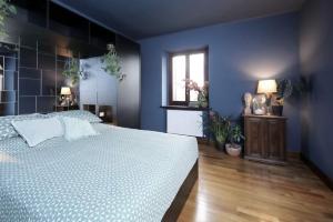 um quarto azul com uma cama branca e uma janela em Viscardo em Tarcento