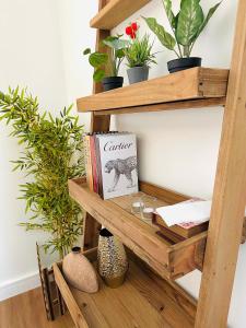 uma estante de madeira com plantas e um livro em 2 Bedroom WoodHouse By Blue Holidays em Sharjah