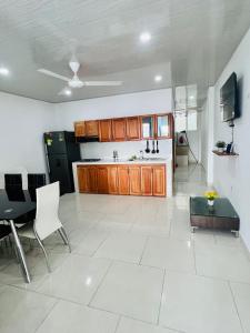 a kitchen with wooden cabinets and a table and chairs at TORRES DEL MESÓN LUXURY APARTMENTS Doradal in Doradal