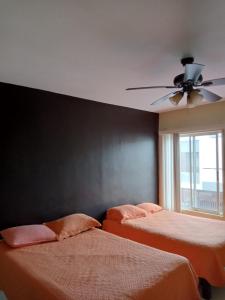 a bedroom with two beds and a ceiling fan at AIRPORT APARTMENT MONTERREY 628 in Monterrey