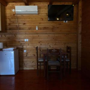 uma cozinha com uma mesa e cadeiras e um frigorífico em Zenith Campsite Apartments em Nikšić