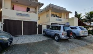 due auto parcheggiate di fronte a una casa di Desfrute Apto 2 Praia de Penha SC e Beto Carrero a Penha