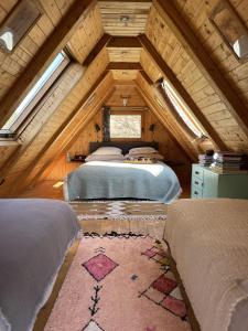 a attic bedroom with two beds and a window at chatky Dokořán in Písek