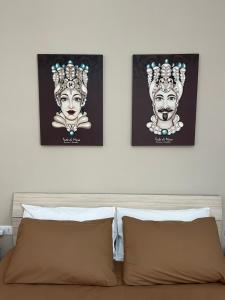 dois cartazes na parede acima de uma cama em Le Terrazze di Chiara em Palermo