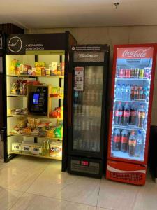 a cocacola soda machine in a store next to a refrigerator at Loft Vista dos Arcos in Rio de Janeiro