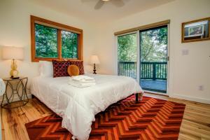 Schlafzimmer mit einem Bett mit weißer Bettwäsche und Fenstern in der Unterkunft Sunrise Cottage in Asheville