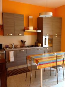 サンタニェッロにあるCasa Tètta two styles living togetherのテーブル付きのキッチン、オレンジ色の壁のキッチン