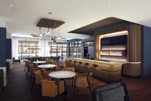 a restaurant with tables and chairs and a bar at Courtyard by Marriott Dallas Frisco in Frisco