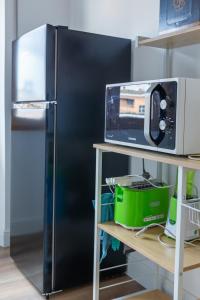 einen schwarzen Kühlschrank in einer Küche neben einer Mikrowelle in der Unterkunft Massi 3 Monteverde in Rom