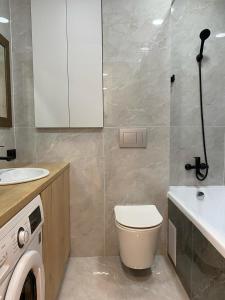 ein Badezimmer mit einem WC, einem Waschbecken und einer Waschmaschine in der Unterkunft Apartaments COSTA 2комн Нурлы жол-62 in Astana