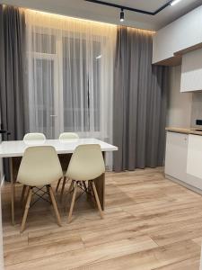 eine Küche mit einem Tisch und Stühlen im Zimmer in der Unterkunft Apartaments COSTA 2комн Нурлы жол-62 in Astana